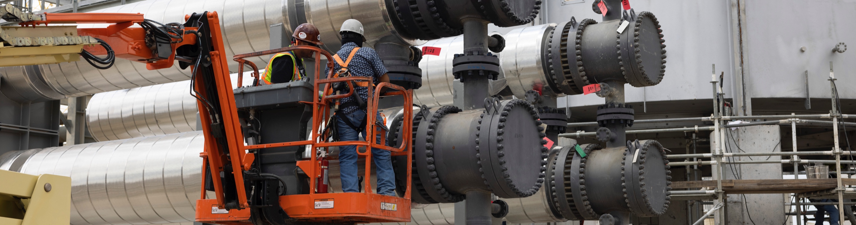 Workers on a lift service plant equipment